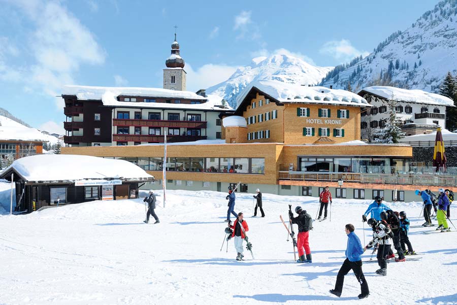 Skifahrer vor Hotel im Dorf